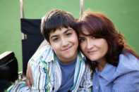 Image of boy in a wheelchair with his mother