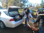Image of volunteers unloading food from car trunk